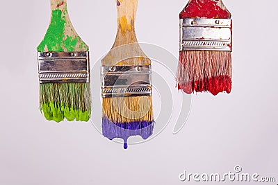 Three paint brushes dripping wet paint red purple and green paint Stock Photo