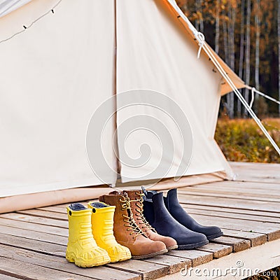 Three pair of shoes near a canvas tent Stock Photo