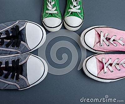 Three pairs of textile worn sneakers on a black background Stock Photo