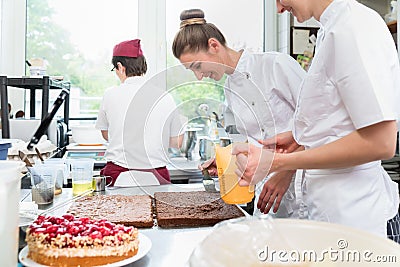 Three pastry bakers in confectionary preparing fruit pies Stock Photo
