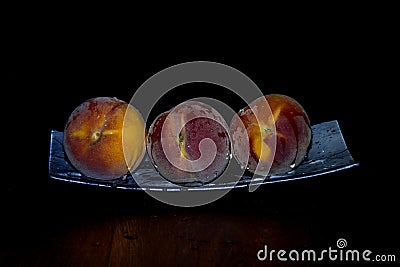 Three peaches on a platter Stock Photo