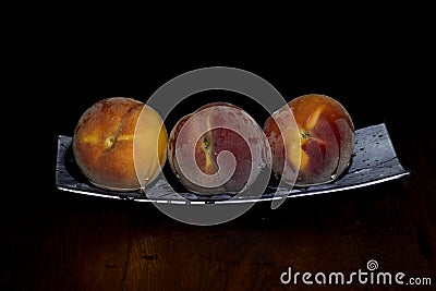 Three peaches on a platter Stock Photo