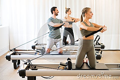 Three people exercising torson rotation at gym Stock Photo