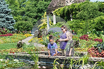 Three people gazing into the pond Editorial Stock Photo