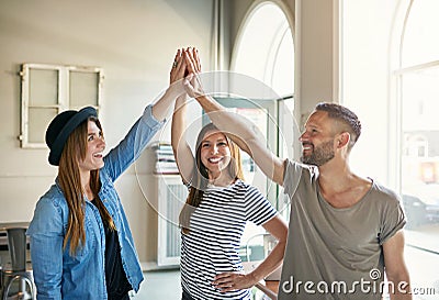 Three people standing and giving high five Stock Photo