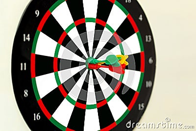 Three perfect darts shoot at the target darts different color red yellow and green Stock Photo