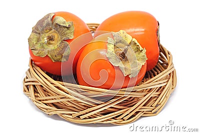 Three Persimmons In a Wicker Bowl Isolated On White Stock Photo