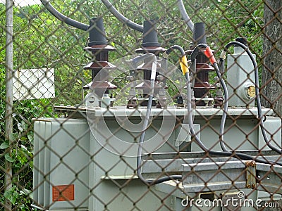 Three phase electrical transformer in fence Stock Photo