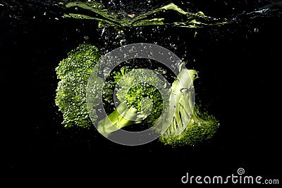 Broccoli pieces splash into the water Stock Photo