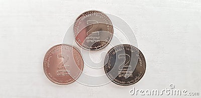 Three coins of two Israeli shekels isolated on white background Stock Photo