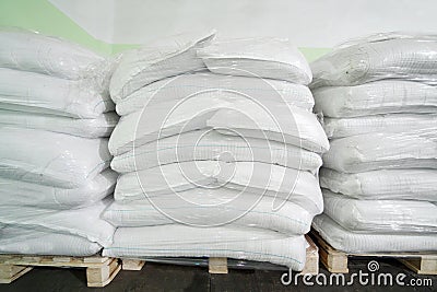 Three piles of big white sacks at large warehouse Stock Photo