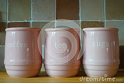 Three pink jugs on a wooden kitchen work surface, with the words Stock Photo