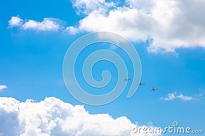 Three planes flying in the blue sky, surrounded by clouds and sunlight Stock Photo