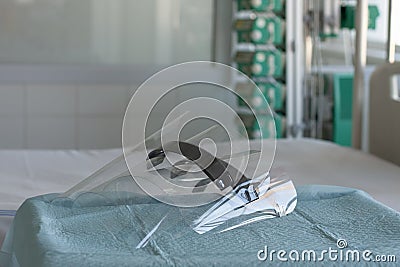 Three plastic protective shields on table in ICU in hospital, personal protective equipment to protect against covid-19 Stock Photo