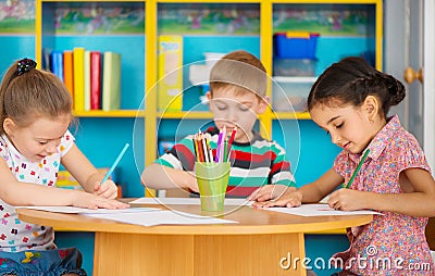 Three preschool children drawing at daycare Stock Photo