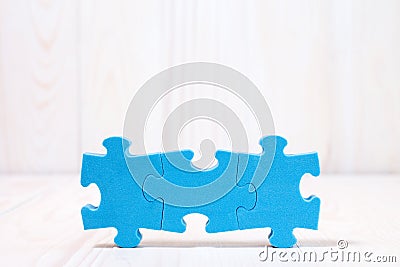 Three puzzle pieces on white wooden background Stock Photo