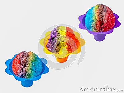 Three rainbow Hawaiian shave ice, shaved ice or snow cone desserts in a row against a white background. Stock Photo