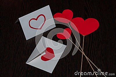 Three red cardboard hearts, on the rays of straws. Stock Photo