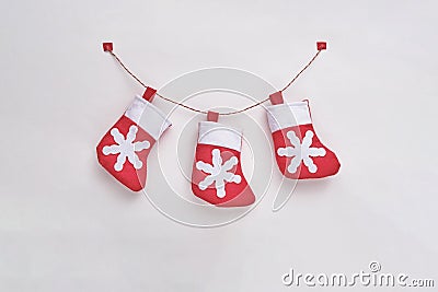 Three red and white toy textile Christmas socks on the tape on the white background Stock Photo