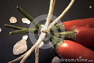 Three related twine red hot peppers on a blackboard. tinted Stock Photo