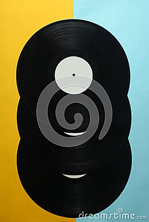 Three retro vinyl records on a colored pastel background. Top View. Stock Photo
