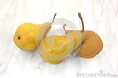 Three ripe bosc pears on cutting board Stock Photo