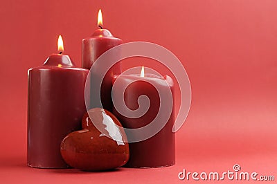 Three romantic red lit candles, horizontal with copy space. Stock Photo