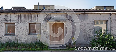 Three rotten curved windows in the yellow plastered wall of a ruined old brick house Stock Photo