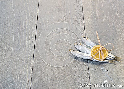 Three sardines with lemon on wooden table Stock Photo