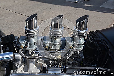Three sets of carburetors on a car engine Stock Photo
