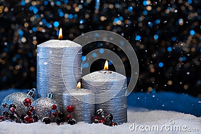Three Silver Candles in snow Stock Photo