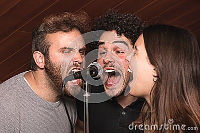 Three singers singing with a microphone with euphoric expression Stock Photo