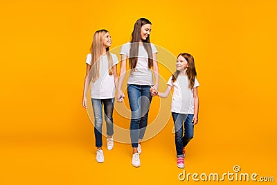 Three sister ladies holding arms spending weekend walking shopping wear casual outfit isolated yellow background Stock Photo