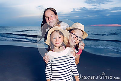 Three sisters having fun on beach, friends on beach in dusk time Stock Photo