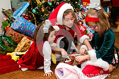 Three Sisters Opening Christmas Presents Stock Photo