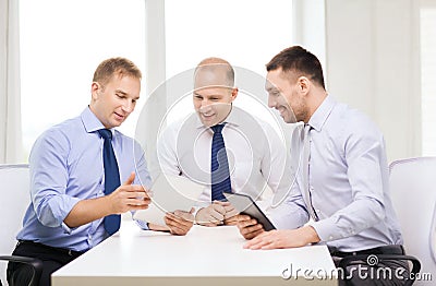 Three smiling businessmen with tablet pc in office Stock Photo