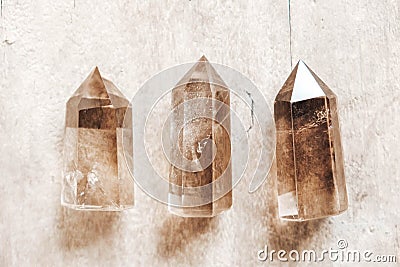 Three smoky natural quartz crystals on wooden background. Top view. Copy, empty space for text Stock Photo