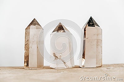 Three smoky natural quartz crystals on a wooden surface on a white background. Copy, empty space for text Stock Photo