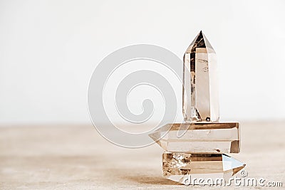 Three smoky natural quartz crystals on a wooden surface on a white background. Copy, empty space for text Stock Photo