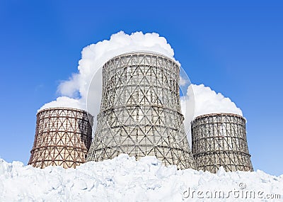 Three soaring evaporators of CHP and a lot of snow against the blue sky. Stock Photo