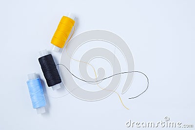 Three spools multicolored sewing thread. White background Stock Photo