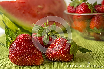 Three strawberries in Huelva on a green tablecloth. Stock Photo