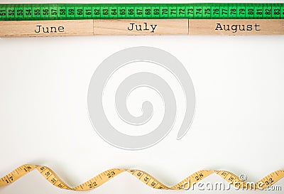 Three summer month - June, July and August - on wooden blocks with centimeter tape isolated on white Stock Photo