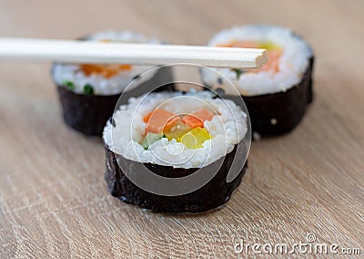 Three sushi rolls with chopsticks Stock Photo