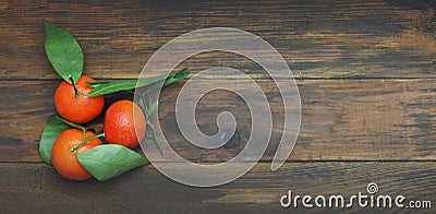 Three Tangerine on a Dark Wooden Table with Copy Space. top view. Banner. Stock Photo