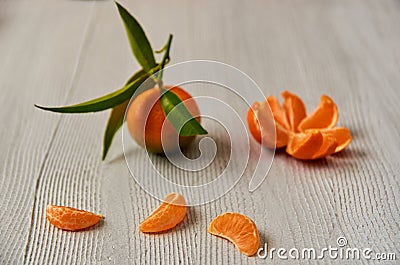 Three tangerine orange slices on the gray wooden board with free copy space. Peeled mandarin orange and fresh raw tangerine Stock Photo