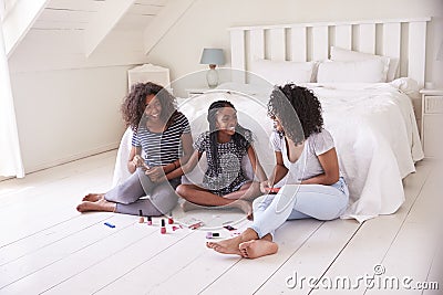 Three Teenage Sisters Giving Each Other Makeover In Bedroom Stock Photo
