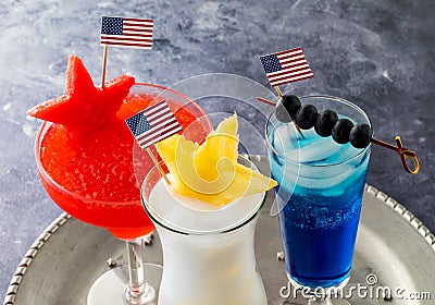 Three 4th of July cocktails garnished with USA flags and fresh fruit. Stock Photo