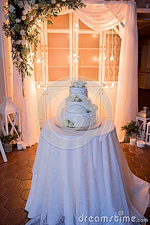 A three tier white wedding cake stands Stock Photo