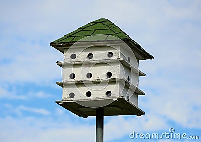 A three tier white wooden bird house with green roof Stock Photo